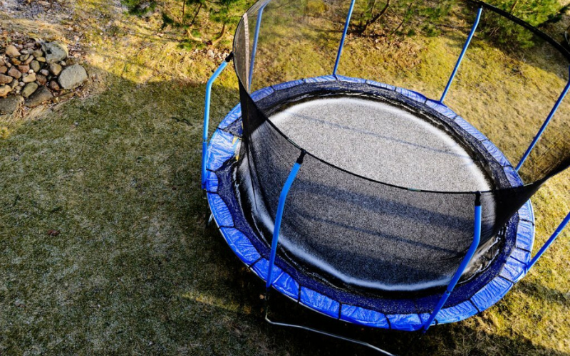 Blue safety pads on a trampoline for a soft landing around the edges.